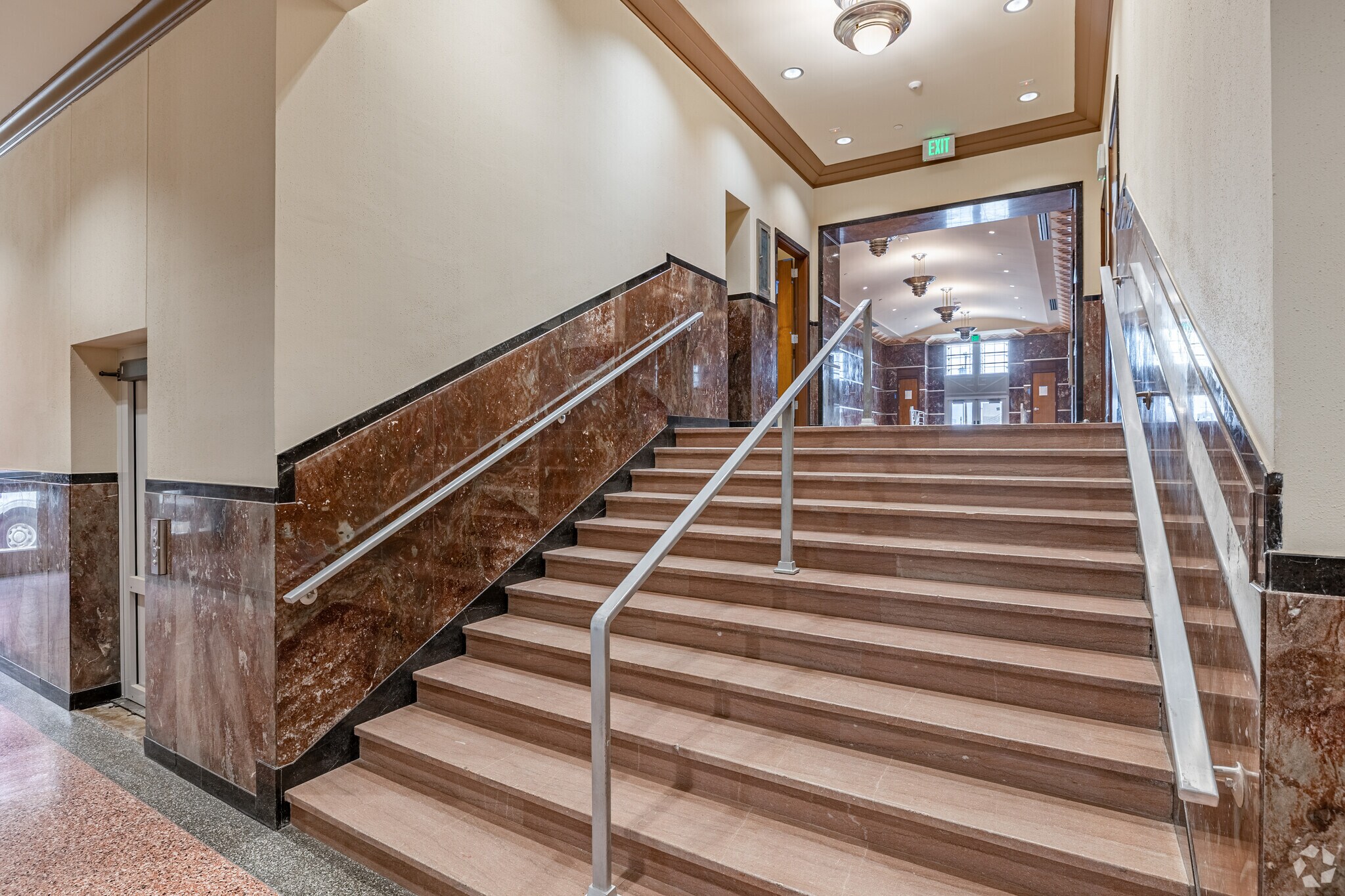 Marble staircase and corridor inside 1141 N Robinson leading to the elevator lobby
